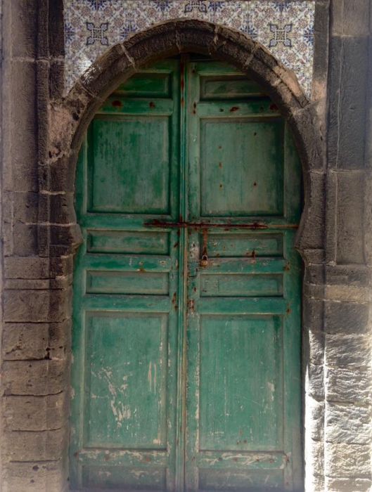Зеленая филёнчатая арочная дверь