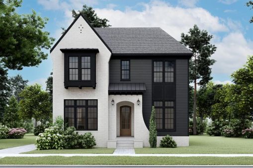 The outside of this Transitional Tudor home plan is beautiful and includes…